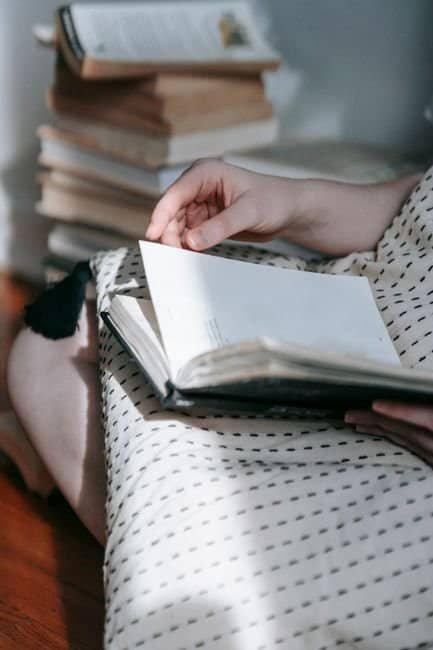 Crop unrecognizable woman with ornamental cushion reading textbook on floor at home on sunny day